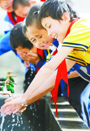 2013年4月24日,体育课后,莎车县托吾斯塘乡中心小学的学生在洗手池里洗手。